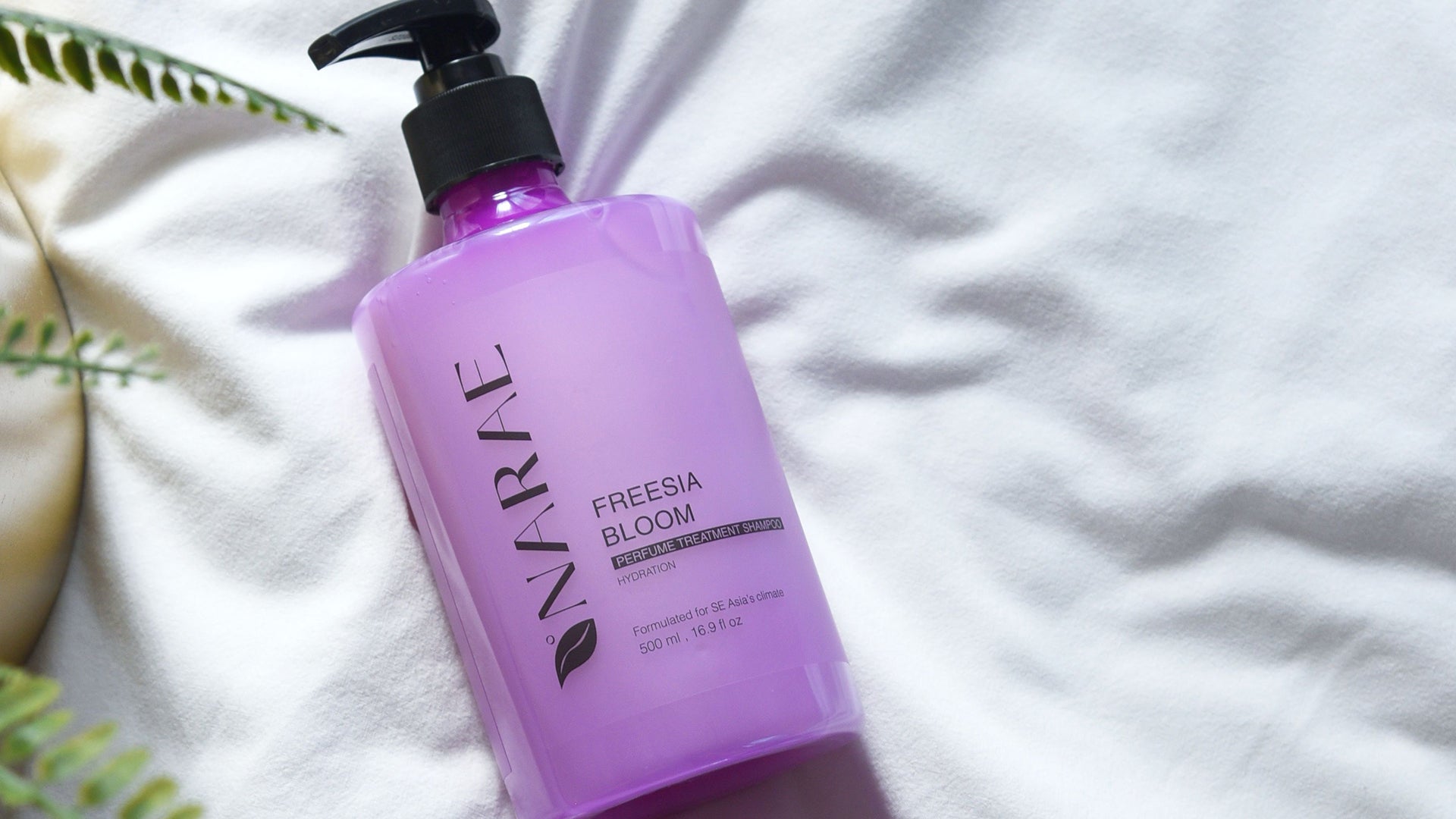 Freesia Bloom Perfumed Shampoo bottle with aloe vera and basil leaf extract, designed to repair dry, frizzy hair and leave a long-lasting floral fragrance.